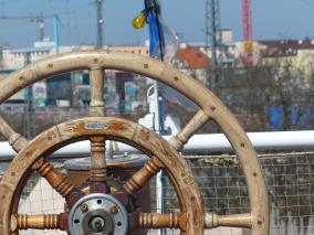 Blick durch Schiffslenkrad auf Silhouette Münchens