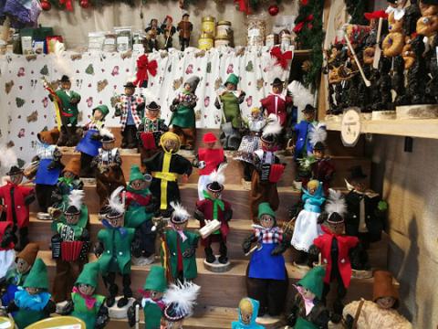 Das Bild zeigt eine Sammlung von handgefertigten Holzfiguren, die traditionelle Charaktere und Weihnachtswichtel darstellen.