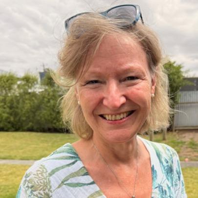 Frau mit Sonnenbrille im Haar lächelt in die Kamera