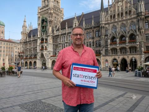 Gästeführer mit Mappe vor dem Neuen Rathaus München