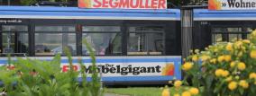 Tram hinter Blumen mit Werbung auf dem Dach