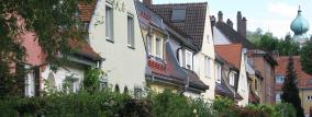 Häuserreihe mit Hecken und Straße
