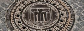 Ein Kanaldeckel mit dem Mönchswappen für München