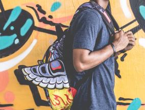 Junge mit Rucksack vor Graffiti